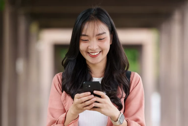 Smart, TNT offers free Facebook data with new promo asian woman using a smartphone